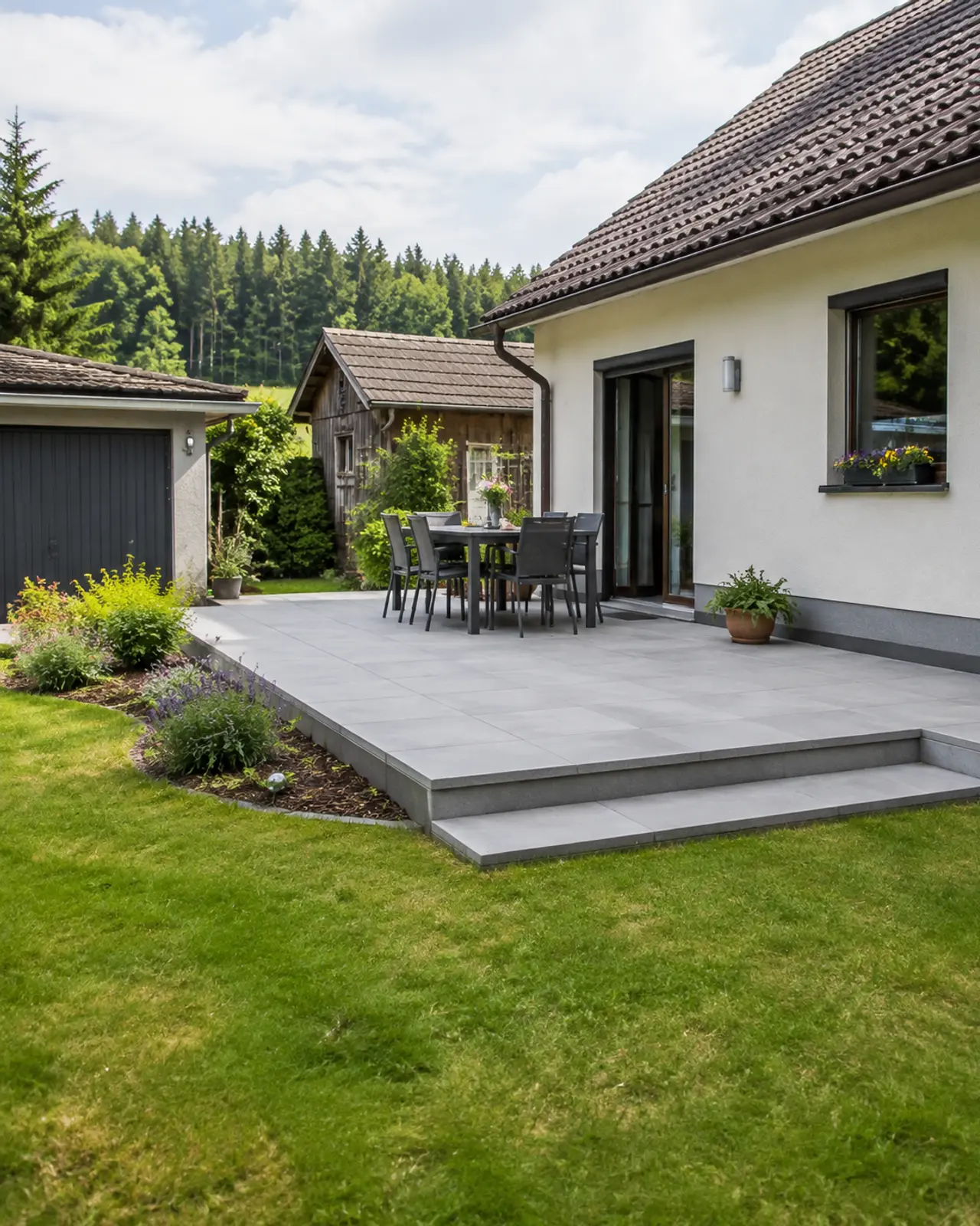 Terrasse aus großformatigen Platten mit angrenzender Stufe zum Garten