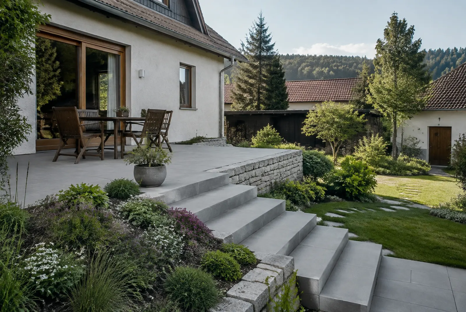 Terrasse am Hang mit Stufen zum tieferliegenden Rasen